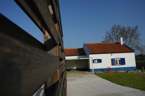 a white and blue house with a red roof at HERDADE PALMA t2 in Moita