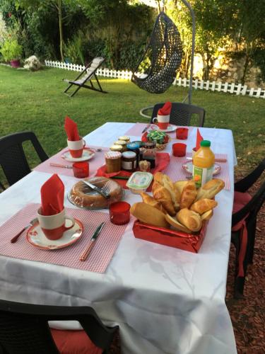 a white table with food on top of it at gîte en pierre le paradis parc clôturé spa jacuzzi 5 places piscine au Périgord pourpre 9km de bergerac in Saint-Aubin-de-Lanquais