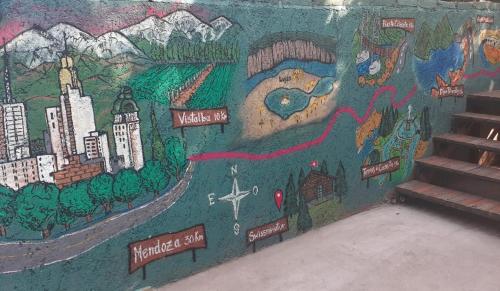 a mural on the side of a wall with stairs at Cabañas swissminiatur in Cacheuta