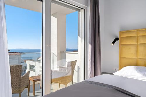 a bedroom with a bed and a view of the ocean at Aquarelle Apartments Primošten apt no 1 and 3 in Primošten