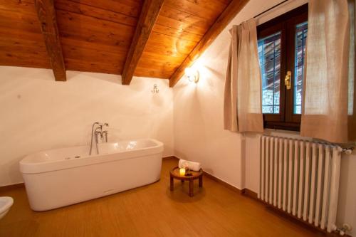 bagno con vasca bianca e finestra di QUATTROVIGNE - Country House a Mango