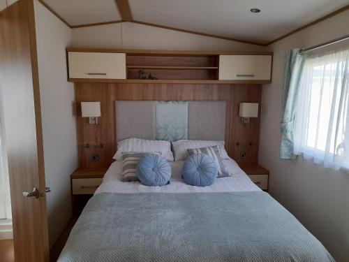a bedroom with a large bed with blue pillows at The Beaches - New Beach in Dymchurch