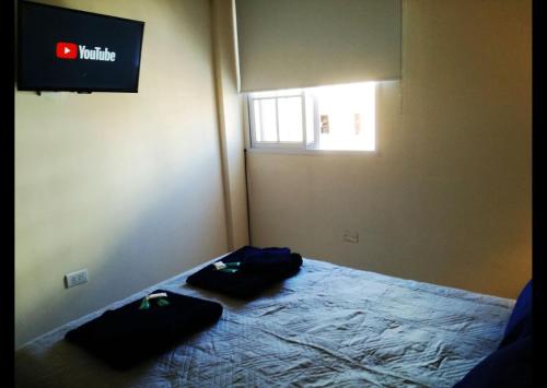 Un dormitorio con una cama con dos bolsas. en Departamento Congreso de Tucuman 561 en San Miguel de Tucumán