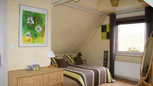 1 dormitorio con cama y ventana en Chambre d'Hotes Le Vogelgarten, en Sigolsheim