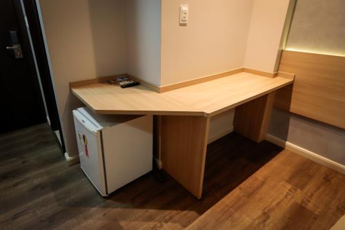 a wooden desk in a room with a refrigerator at Hotel Pousada da Serra in Maracaju