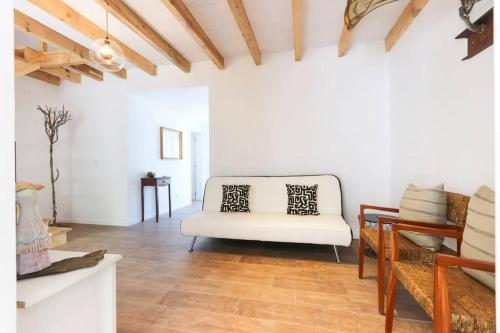 a living room with a white couch and a table at CAPARICA BEACH VILLA in Trafaria