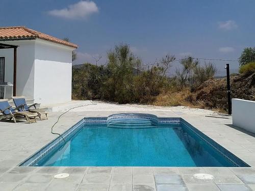 - une piscine en face d'une maison dans l'établissement Belvilla by OYO Casa de Aguila, à Almogía