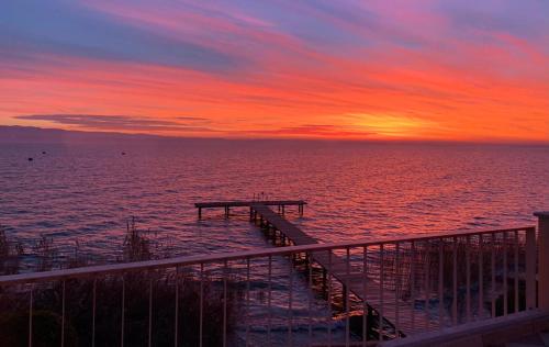 a dock in the ocean with a sunset at Hotel Alfieri in Sirmione