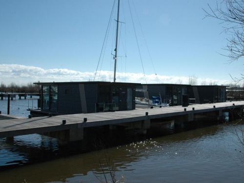 un muelle con un edificio sobre el agua en Beautiful Houseboat in the harbour of Volendam near Centre, en Volendam