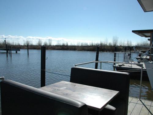 einen Tisch und Stühle auf einem Boot im Wasser in der Unterkunft Beautiful Houseboat in the harbour of Volendam near Centre in Volendam