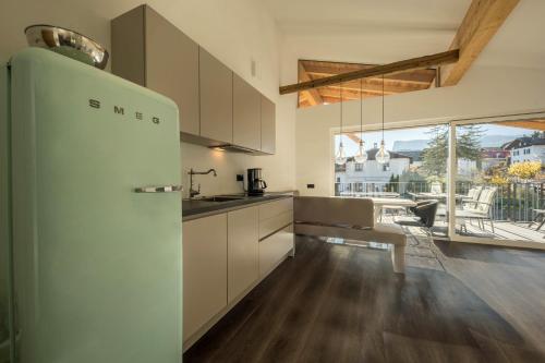 a kitchen with a white refrigerator and a table at latemar - schlosserhaus 31 in Tesimo