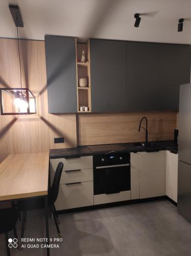 a kitchen with a table and a black appliance at New loft style apartment in Uzhhorod