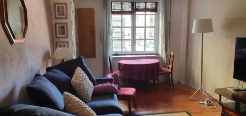 un salon avec un canapé, une table et une fenêtre dans l'établissement Les Clés de St Pierre F2, au Puy-en-Velay