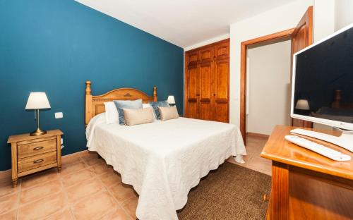 a blue bedroom with a bed and a television at Luxury Diving Apartment in Puerto del Carmen