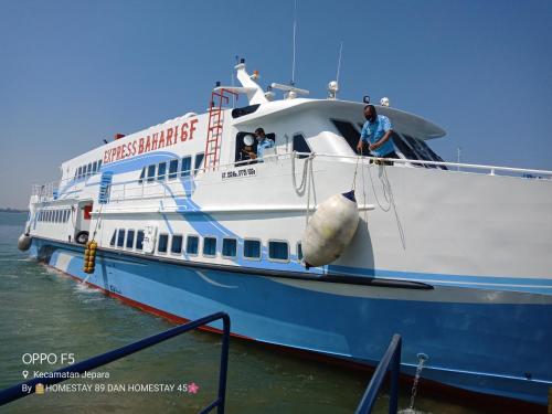 a large blue and white boat in the water at Homestay 89 New in Jepara