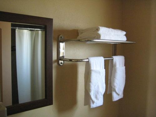 a bathroom with towels on a towel rack and a mirror at Americas Best Value Inn - Porterville in Porterville