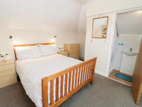 a bedroom with a large bed and a bathroom at Dunromin in Llandudno