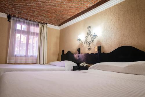 Ein Bett oder Betten in einem Zimmer der Unterkunft Hotel Hacienda de Cobos
