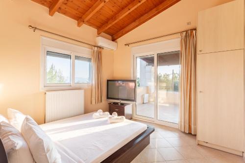 a bedroom with a large bed and a tv at Maisonnette D'Amira in Eretria