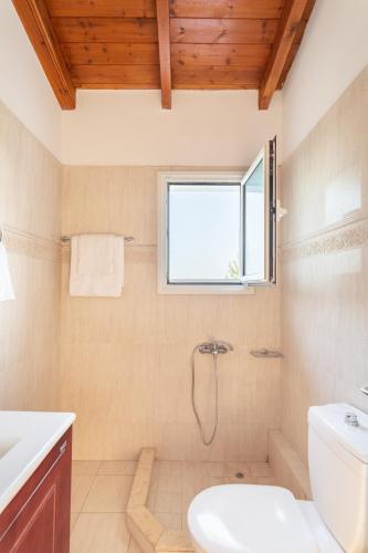 a bathroom with a toilet and a window at Maisonnette D'Amira in Eretria