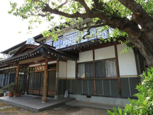 a building that has a tree in front of it at Minshuku Miyama in Yamanouchi