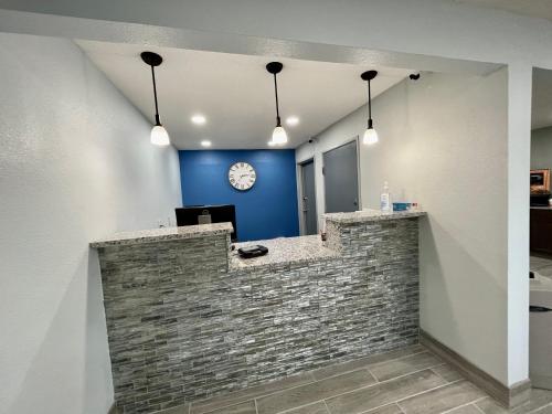an office with a brick wall and a clock on a wall at Lamoni Inn & Suites in Lamoni