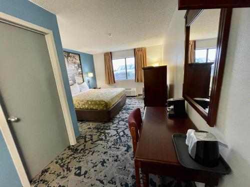a hotel room with a bedroom with a bed and a desk at Lamoni Inn & Suites in Lamoni