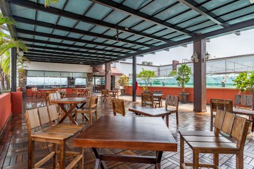 an empty restaurant with wooden tables and chairs at Paris FC Hotel in Poza Rica de Hidalgo