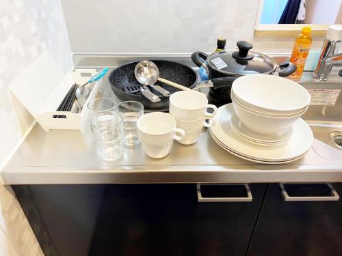 a kitchen counter with dishes and glasses on it at @RLiS_house大阪ドームシティ in Osaka