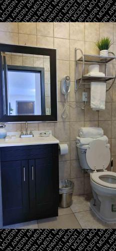 a bathroom with a sink and a toilet and a mirror at The White Bungalow in Rosarito