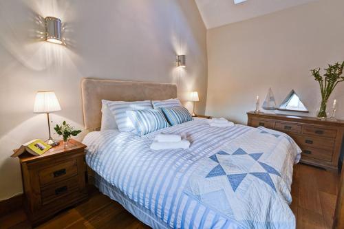 a bedroom with a bed with a blue and white comforter at Borthwen Bach in Llanrhyddlad