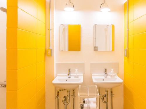 a bathroom with two sinks and two mirrors at Seawall Hostel in Chatan