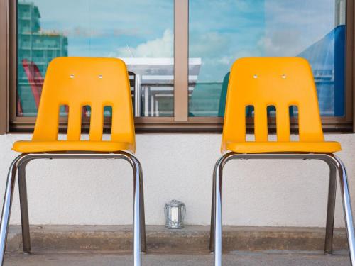 two orange chairs sitting in front of a window at Seawall Hostel in Chatan