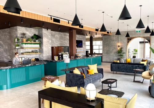 a lobby with couches and tables and a bar at Sudima Auckland City in Auckland