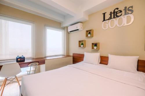 a bedroom with a bed and a sign that reads life is good at Modern and Compact Studio at Patraland Urbano Apartment By Travelio in Bulanbulan