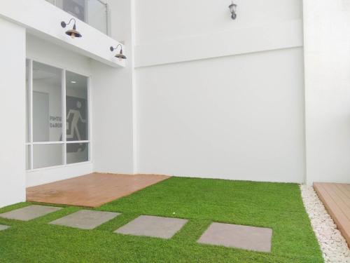 a room with green grass on the floor at Modern and Compact Studio at Patraland Urbano Apartment By Travelio in Bulanbulan