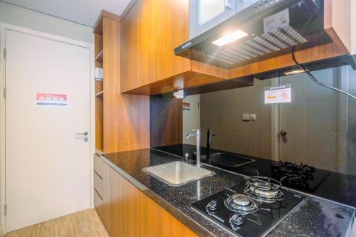 a kitchen with a sink and a counter top at Modern and Compact Studio at Patraland Urbano Apartment By Travelio in Bulanbulan