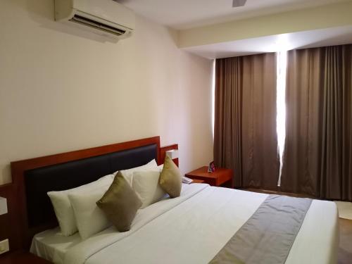a bedroom with a bed with white sheets and pillows at HOTEL GEO in Cochin
