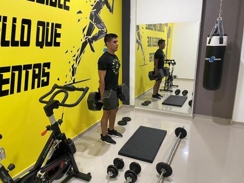 a man standing in a gym with weights at Hotel Santa Clara Boutique in Montería