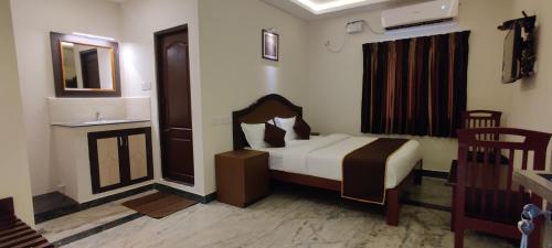 a bedroom with a bed and a sink and a mirror at Rmc travellers inn in Chennai