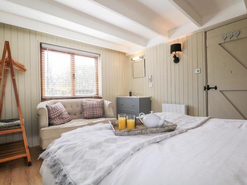 a bedroom with a bed with a tray of orange juice at Woodmancote Lodge in Linchmere