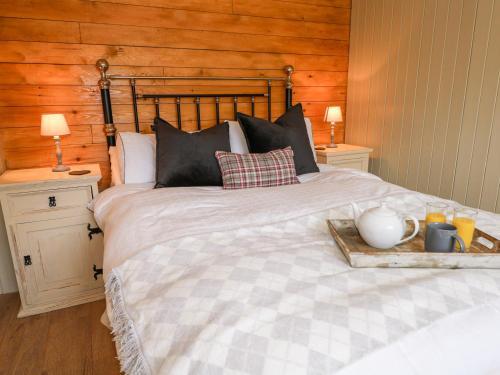 a bedroom with a large bed with a wooden wall at Woodmancote Lodge in Linchmere