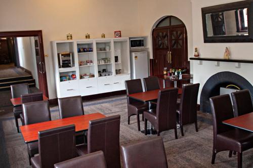 uma sala de jantar com mesas e cadeiras e uma lareira em Hydro Hotel em Leeton