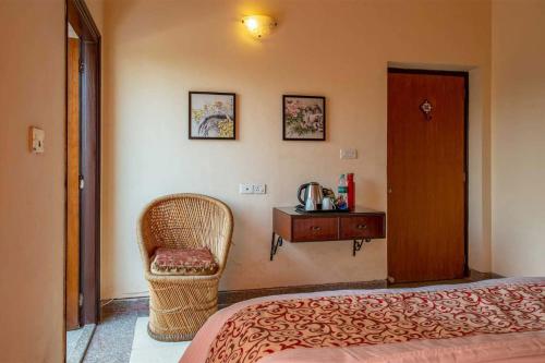 a bedroom with a bed and a chair and a table at Taruchaya by VEO - Part of StayVista in Raichak