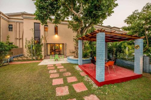 a gazebo in the yard of a house at Taruchaya by VEO - Part of StayVista in Raichak