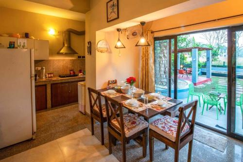 a kitchen and dining room with a table and chairs at Taruchaya by VEO - Part of StayVista in Raichak