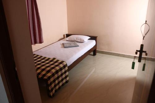 a small bedroom with a bed and a chair at Paradise corner in Pondicherry