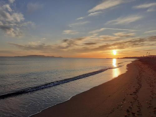 a beach with the sun setting over the water at Sea and Sun in Amoudara Herakliou