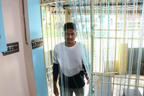 a man is standing in front of a cage at Paradise corner in Pondicherry