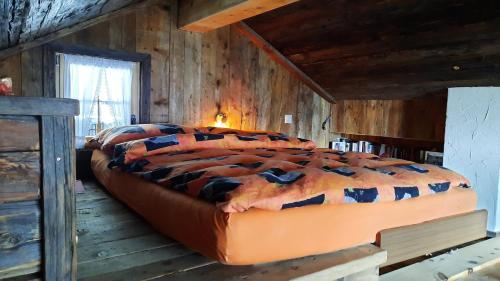 a bedroom with a large bed in a cabin at Atelier Berg zum Bildji in Staldenried